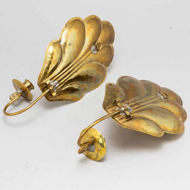 Four brass wall sconces  and one brass plate by Lars Homström, Arvika, second half of the 20th century.