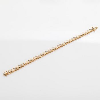 A 14K gold tennis bracelet, with brilliant-cut diamonds.