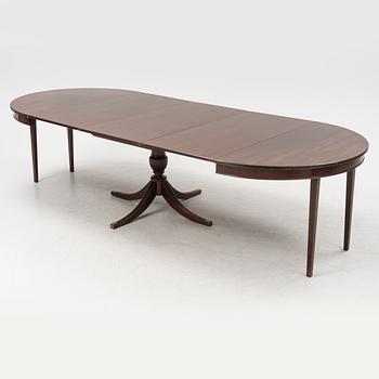 A round mahogany dining table with three additional leaves.