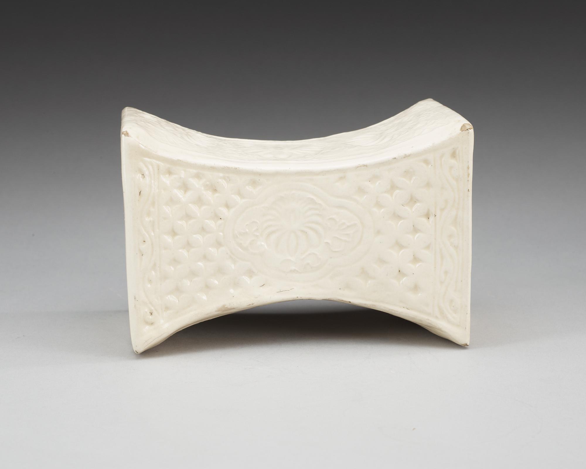 A cream glazed pillow, Song/Jind dynasty. With seal marks of a family and a date to the short sides.