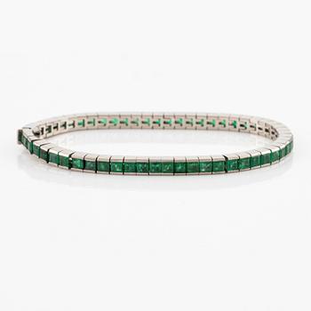 An 18K white gold bracelet with step-cut emeralds.