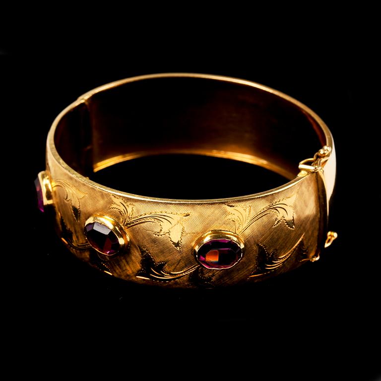 ARMBAND. 18k guld med tre ovalslipade lila stenar. 28g.