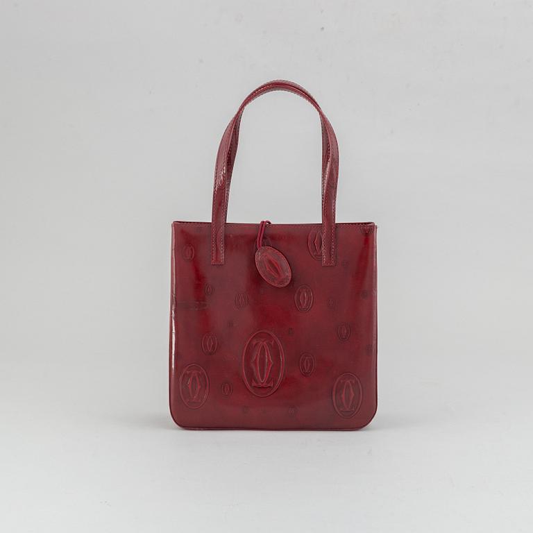 Cartier, a burgundy patent leather handbag and wallet.