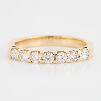 An 18K gold ring set with round brilliant cut diamonds.