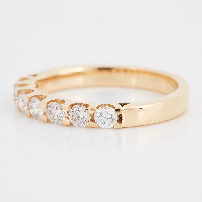 An 18K gold ring set with round brilliant cut diamonds.