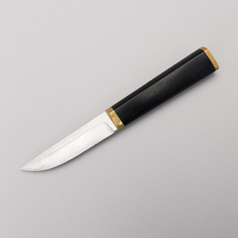 A Finnish puukko knife in stainless steel, nylon and brass designed by Tapio Wirkkala, Hackman Finland.