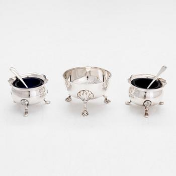 A pair of sterling silver salt cellars, two salt spoons, and a bowl, Sheffield 1898 and 1915, Birmingham 1923 and 1947.