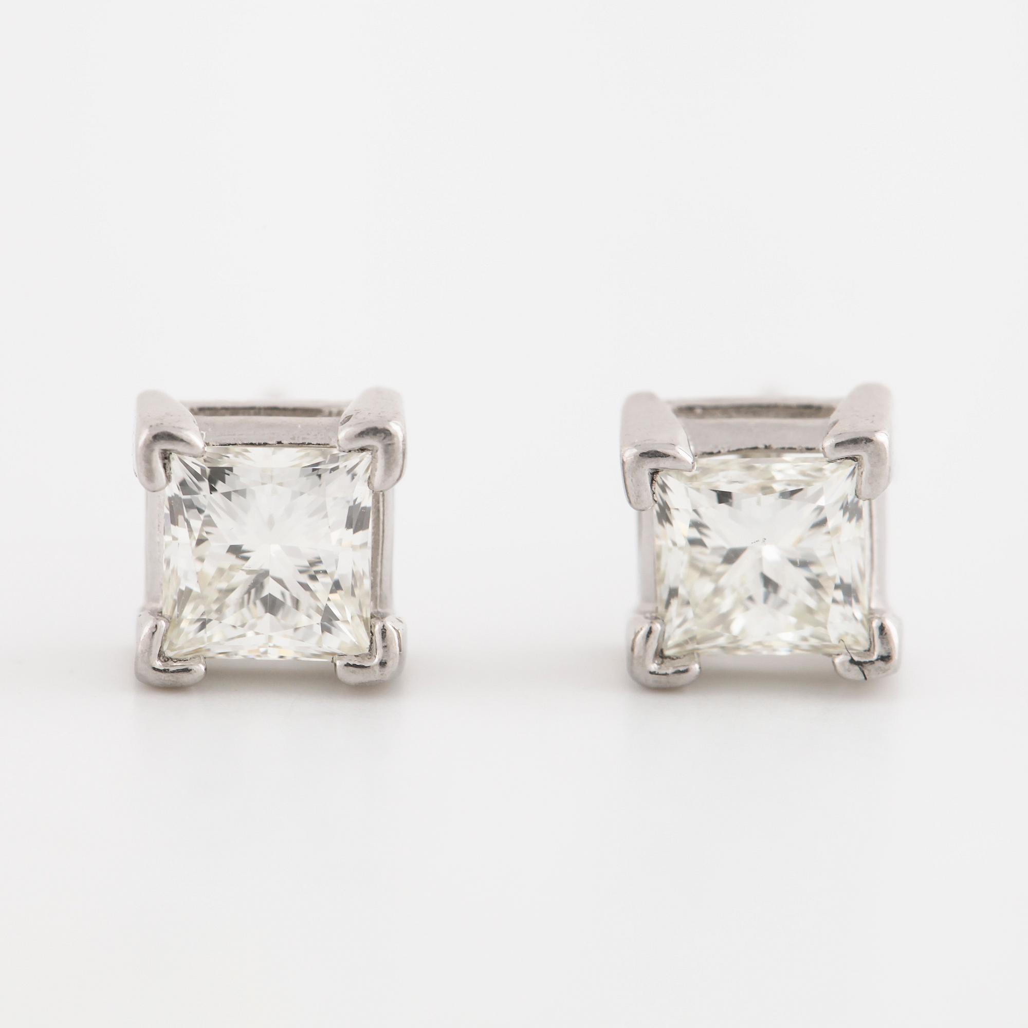 A pair of princess cut diamond earrings.