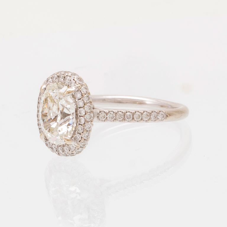 An 18K white gold ring by James Allen, set with an oval brilliant cut diamond in a halo of round brilliant cut diamonds.