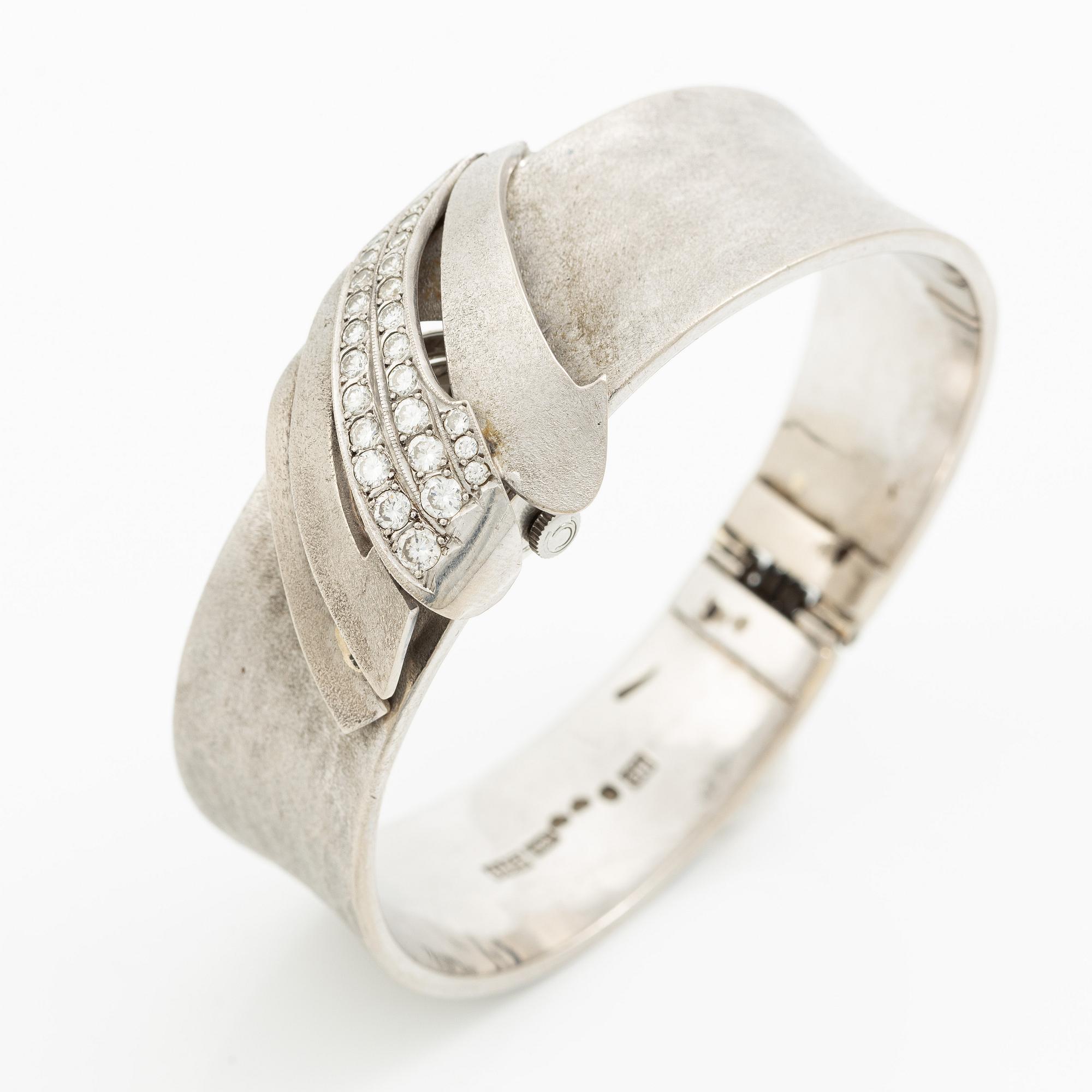 Aftonklocka/armring, Bo Dolk, 18K vitguld med briljantslipade diamanter, 1970-tal.