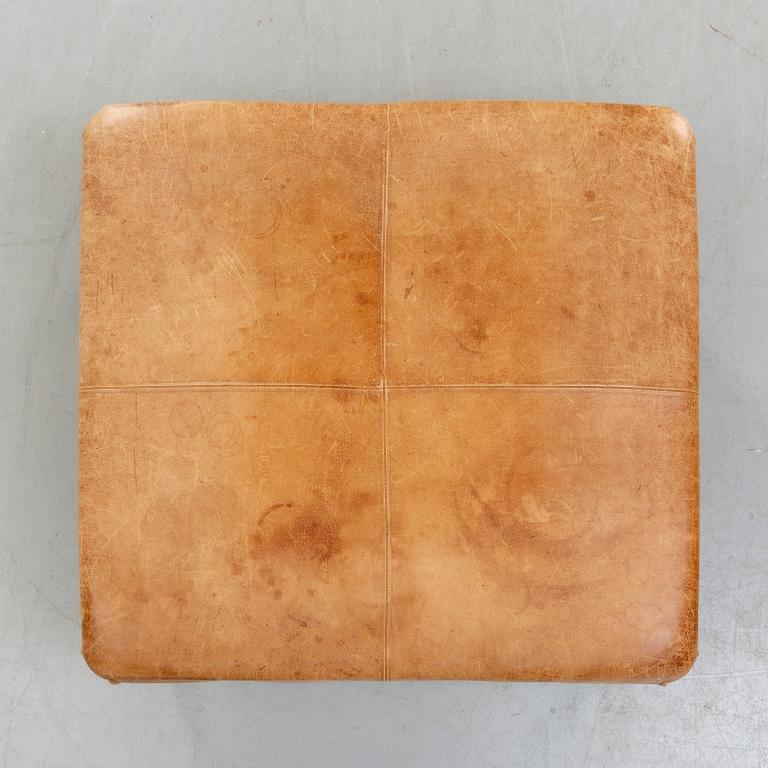A leather ottoman/coffee table alter part of the 20th century.