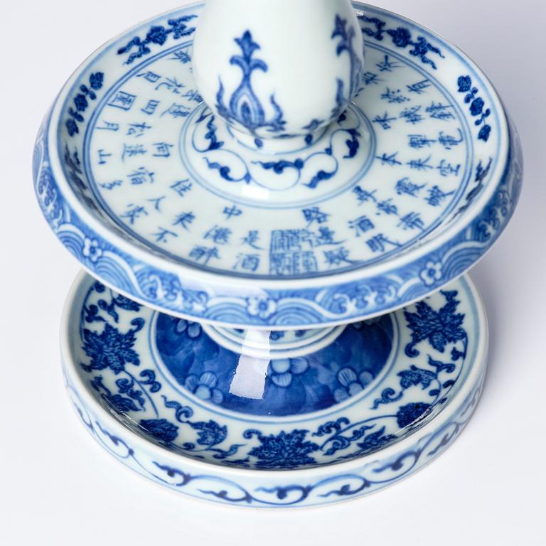 A pair of blue and white pricket candle sticks, with a poem, Qing dynasty with a Qianlong mark and of the period.