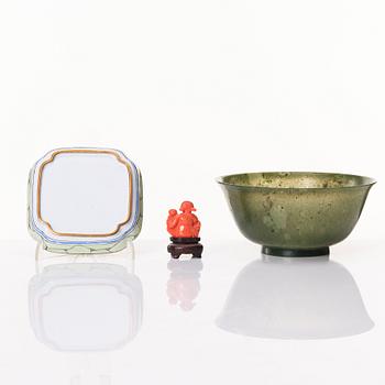 A Chinese enamel on copper coaster, a green stone bowl and a small stone figure, China, Qing dynasty and 20th century.
