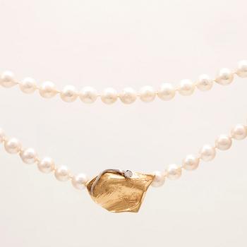 A necklace of cultured pearls, lock in 18K white and red gold set with a round brilliant cut diamond by Ole Lynggaard.