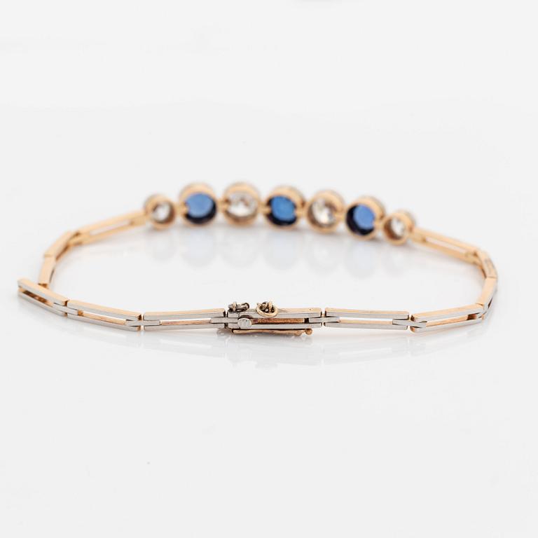 An 18K gold bracelet set with sapphires and old-cut diamonds.