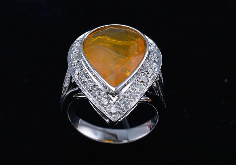 A RING, fire opal, brilliant cut diamonds c. 0.63 ct. 18K white gold. Weight 8,5 g.