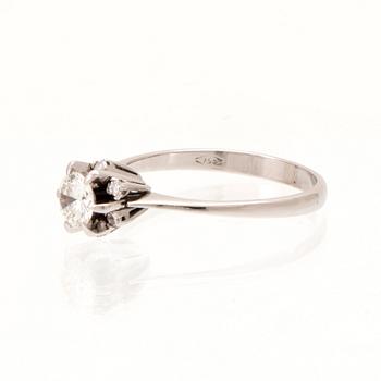 An 18K white gold ring set with a round brilliant cut diamond and single cut diamonds.
