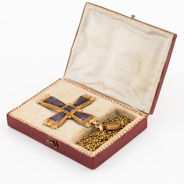 An 18K gold cross with amethysts with a 23K gold chain.