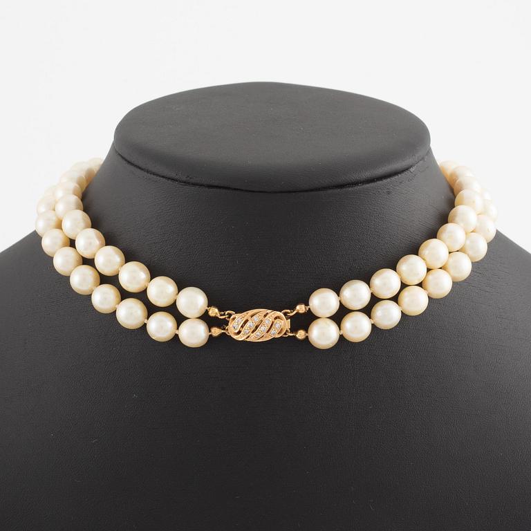 Necklace of two strands of cultured pearls, clasp with 18K gold lock set with eight-cut diamonds.