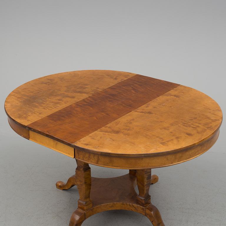 A first half of the 20th century dining table veneered with birch. With three extension leaves.