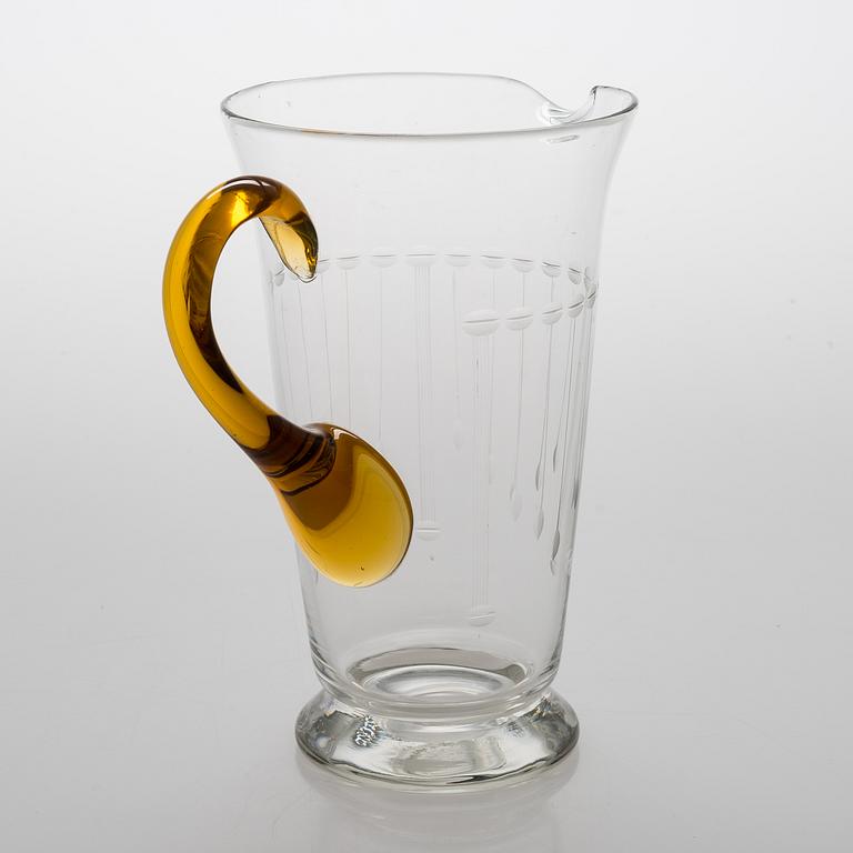 A glass pitcher with six glasses from around the 1920s.