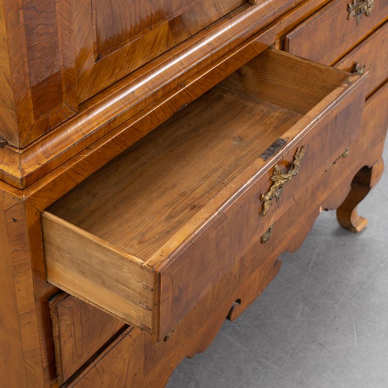 A walnut-veneered rococo cabinet in the manner of C. Linning, later part of the 18th Century.