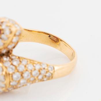 An 18K gold ring set with two facted rubies and round brilliant-cut diamonds.