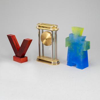 A collection of three sculptures and a mantel clock.