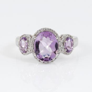 RING, 14k vitguld med tre ovalslipad ametist tot ca 2,03 ct omgivs av små åttkantslipade diamanter. Vikt 4,08 g.