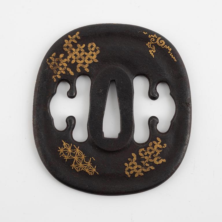 An iron part gilt Japanese tsuba, Edo (1603-1868). In a kiri box.