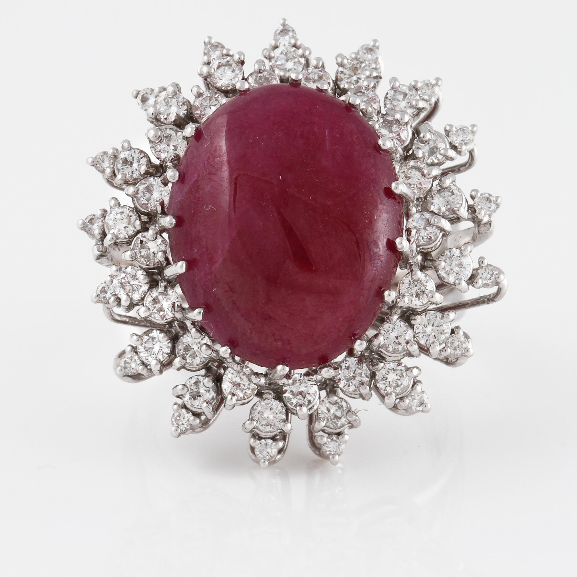 RING, 18K vitguld med naturlig cabochonslipad rubin, 16.15 ct samt små briljantslipade diamanter. Vikt 14,1 gram.