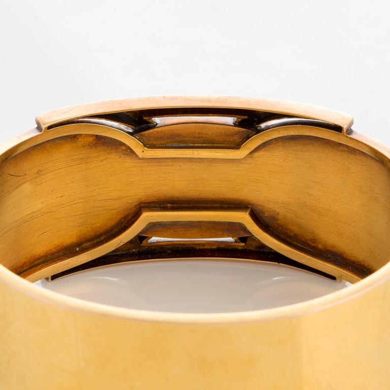 A 14K gold bangle set with a cabochon-cut garnet.