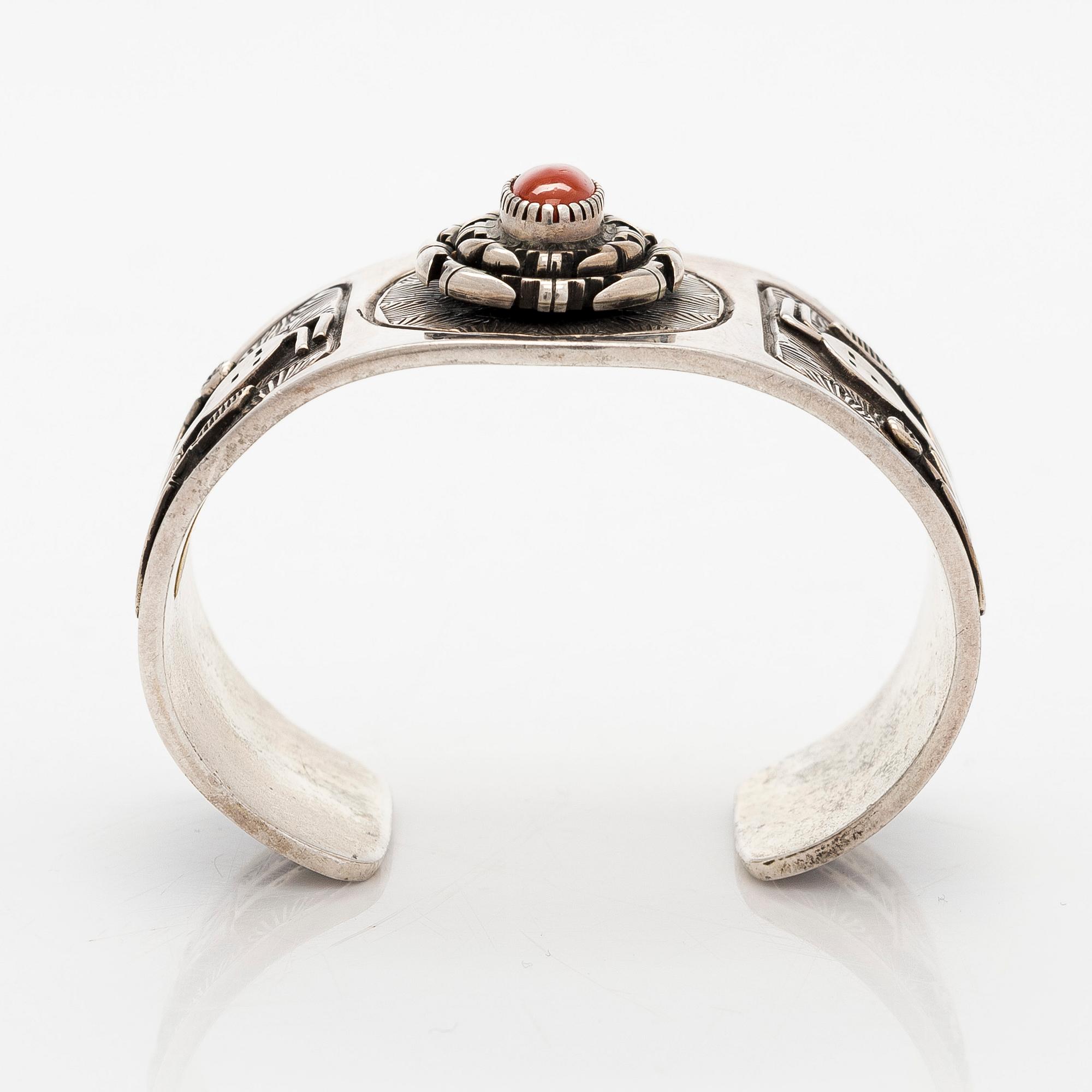 A silver bracelet with coral.