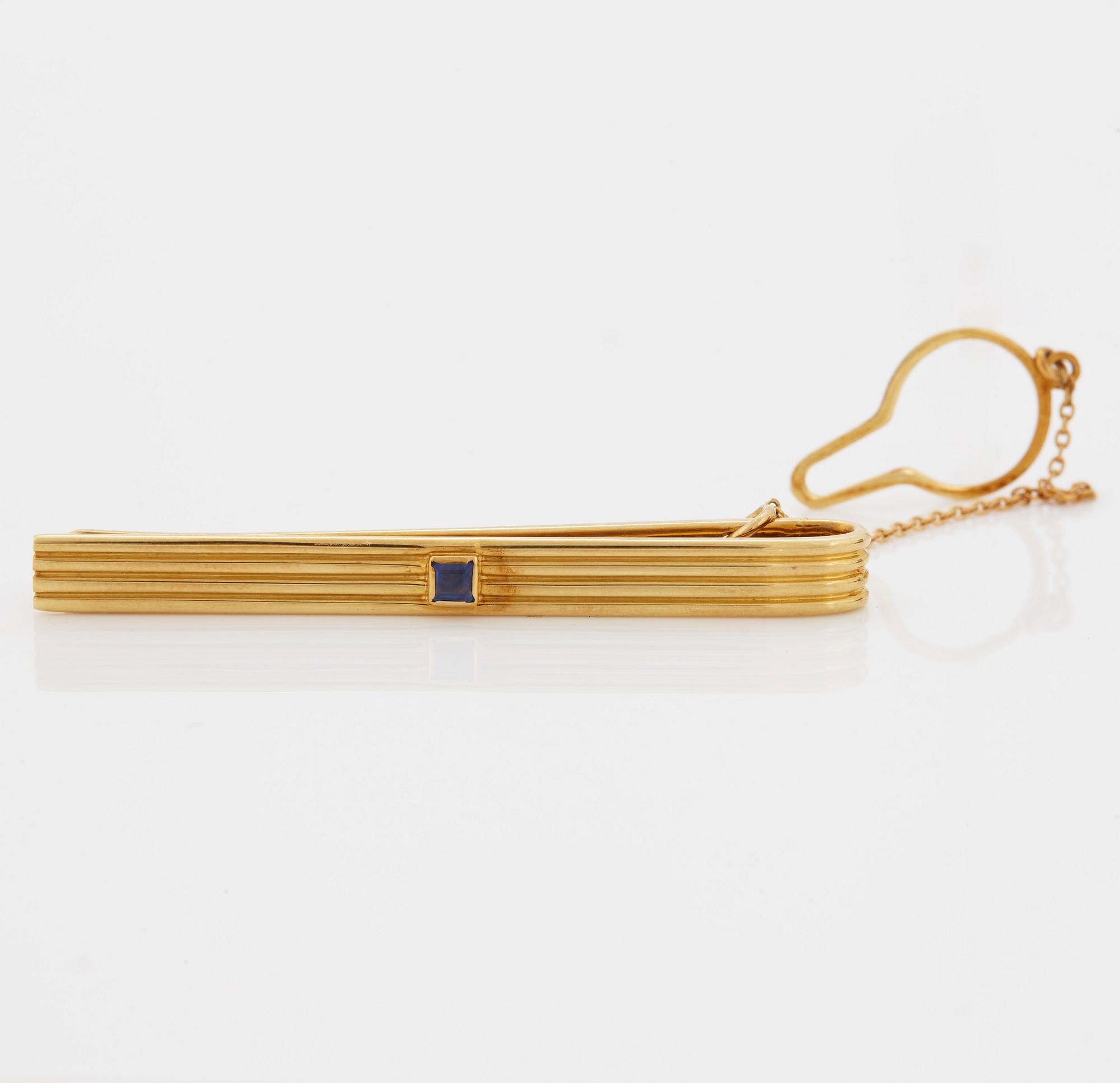 A 1960/70's tie-clip decorated with a carré-cut sapphire by Dupont, Paris.