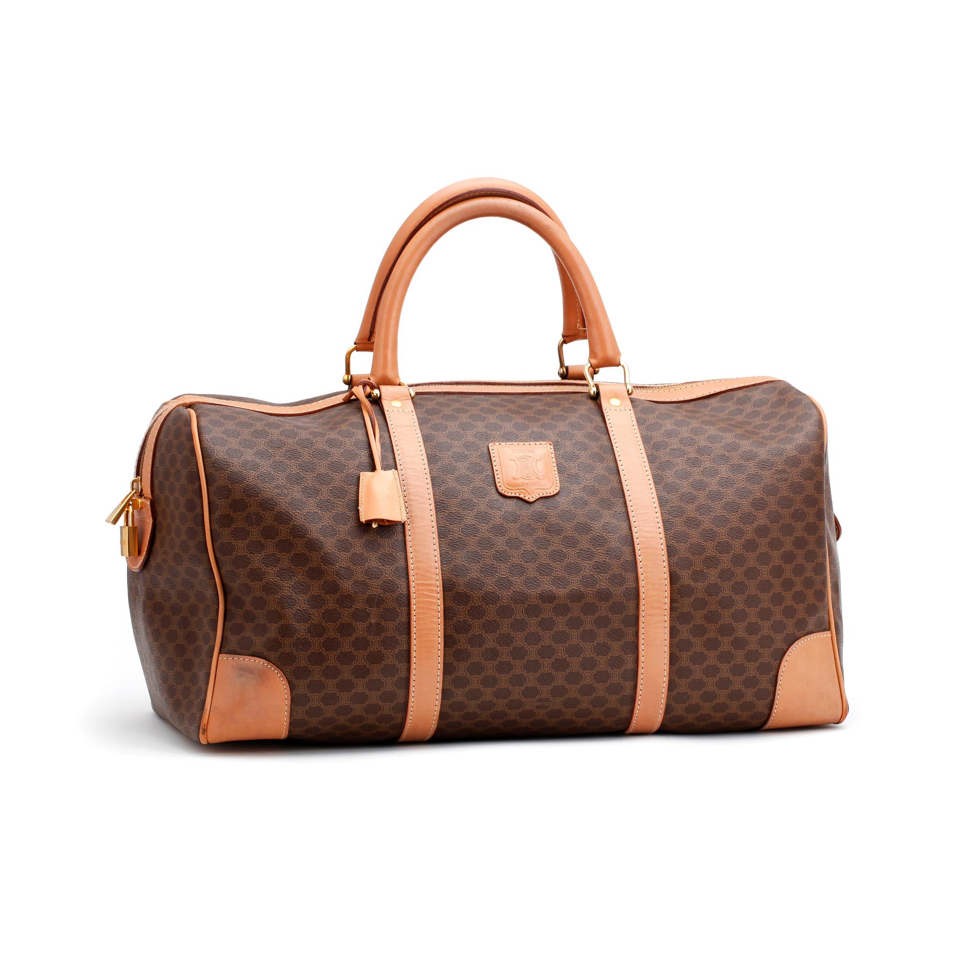 CÉLINE, a brown coated monogram canvas weekend bag.