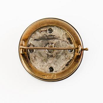 A 14K gold and silver brooch with an onyx, rose cut and old cut diamonds ca 1.3 ct in total. St. Petersburg 1898-1903.
