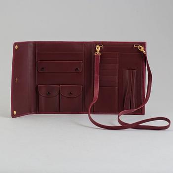 A burgundy leather bag from les must de Cartier.