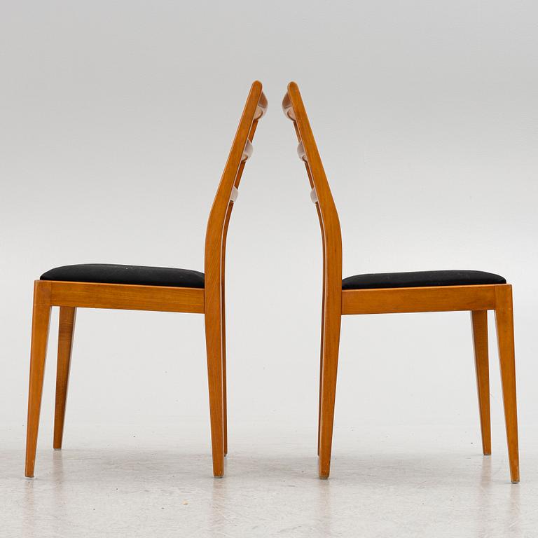 A dining table with four chairs, mid 20th century.