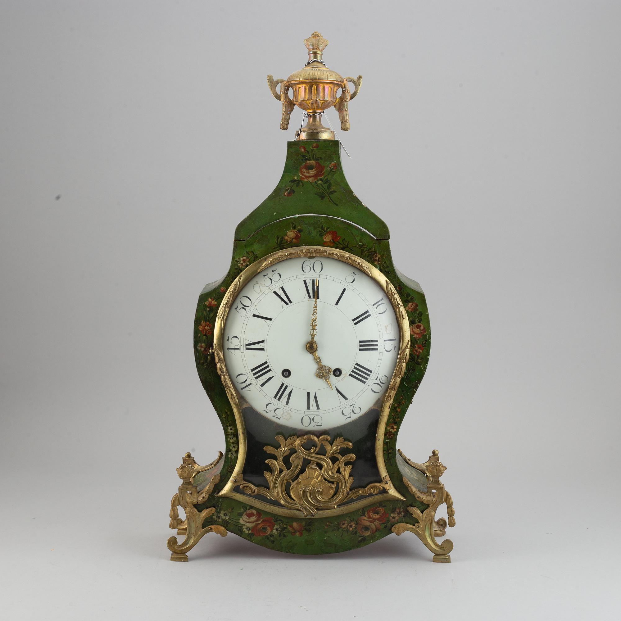 A rokoko style table clock. Pendulum and two keys. 19/20th century.