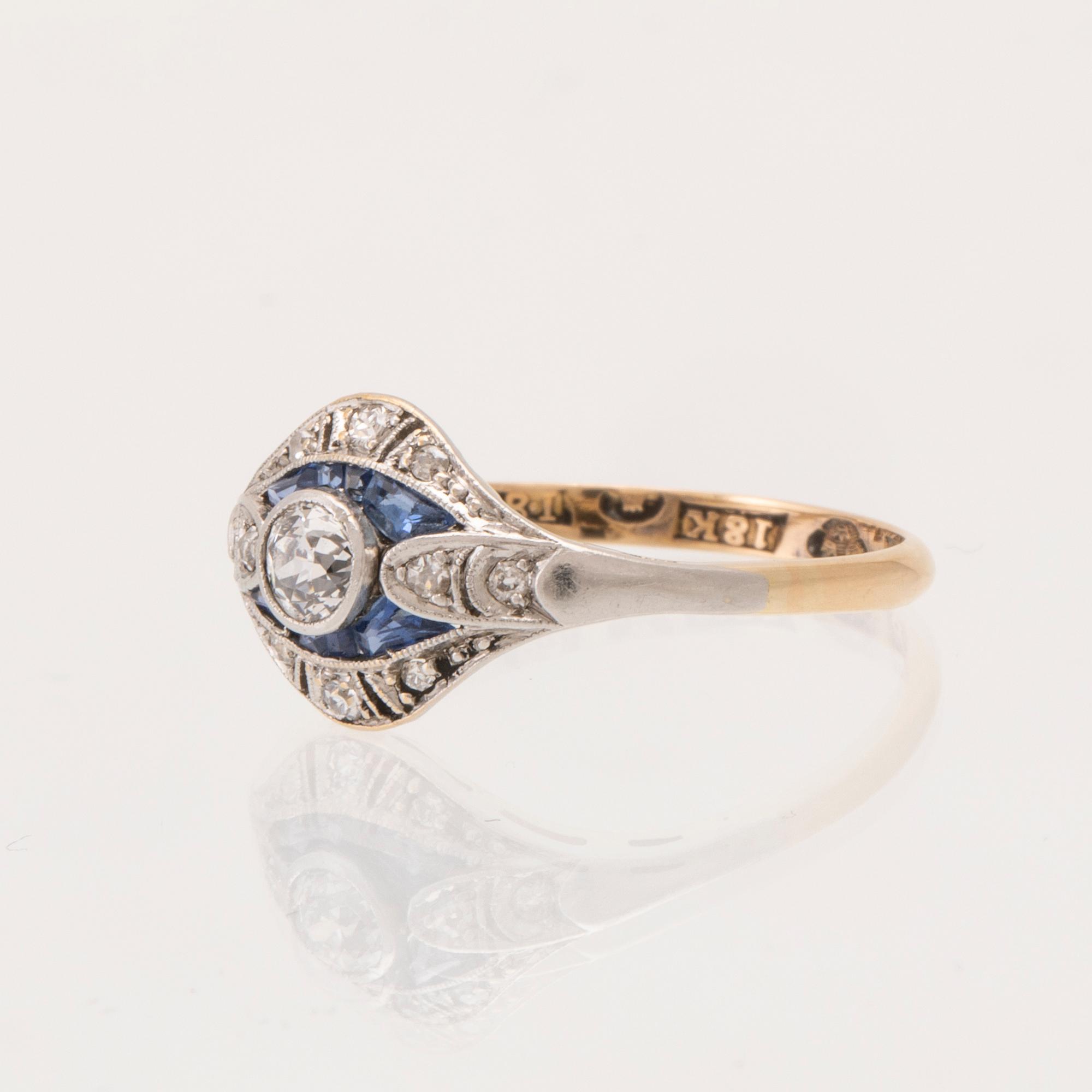 An 18K white and red gold ring set with old-cut diamonds and step-cut blue gemstones, Petterssons Stockholm 1937.