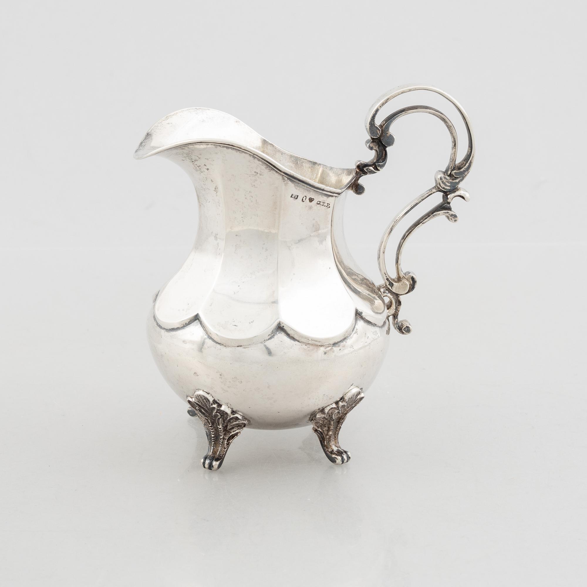 A silver cream jug, mark of Gustaf Theodor Folcker, Stockholm 1856 and a spice jar, Carl Stahle, St Petersburg 1837.