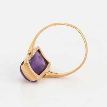 A ring set with a cabochon-cut amythest.