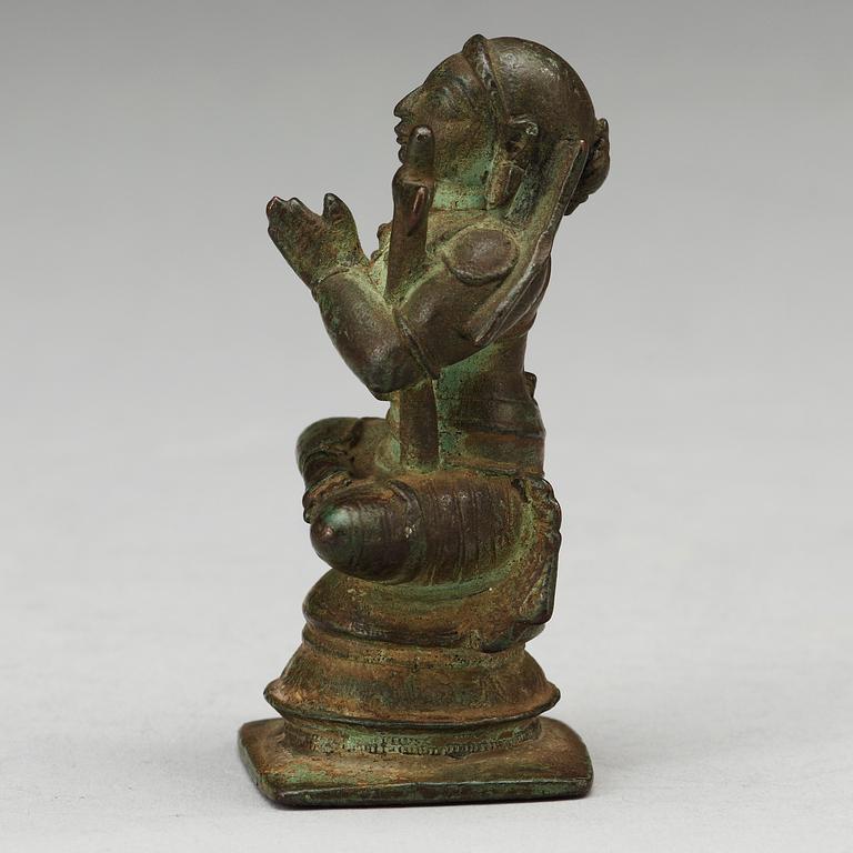 A bronze figure of a seated deity, South-East Asia, presumably 15/16th Century.