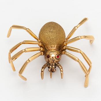 An 18K gold spider brooch with ruby eyes.