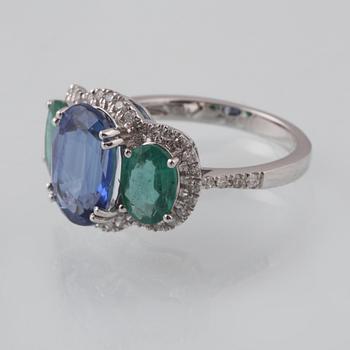 RING, 18K vitguld med fasettslipad kyanit 3.49 ct, 2 smaragder 1.23 ct och briljantslipade diamanter 0.33 ct. Vikt 3 g.