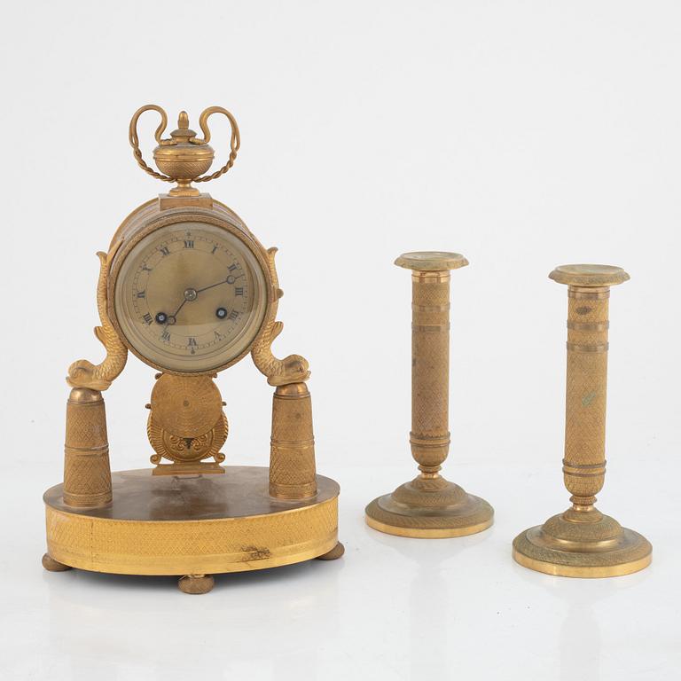 An Empire-style gilt bronze mantel clock and a pair of candlesticks, 20th century.