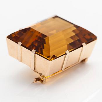 A ca 13K gold brooch, set with a step-cut Madeira citrine approximately 119.0 ct.