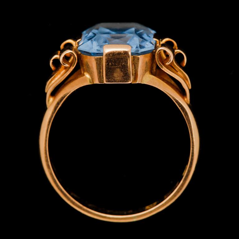 RING, 18k guld med fasettslipad blå glassten. 1928. Vikt 6,6 g.