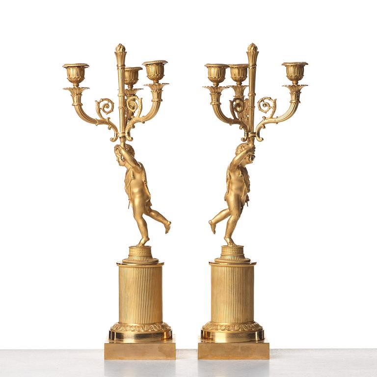 A pair of French Empire early 19th century three--light candelabra.