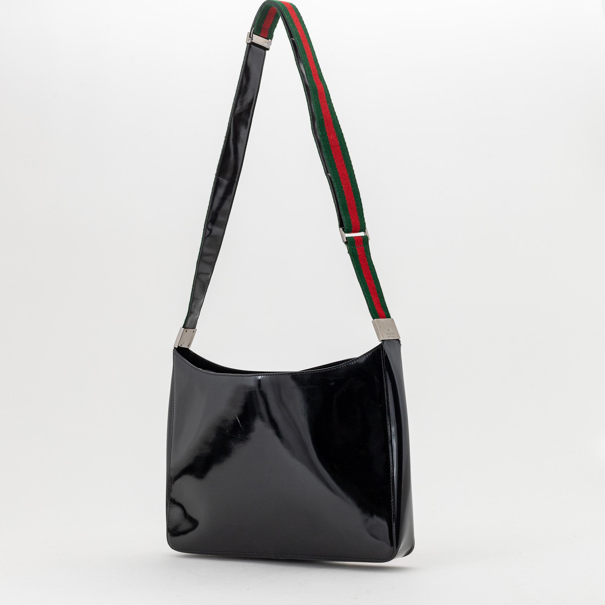 Gucci, a black, patent leather handbag.